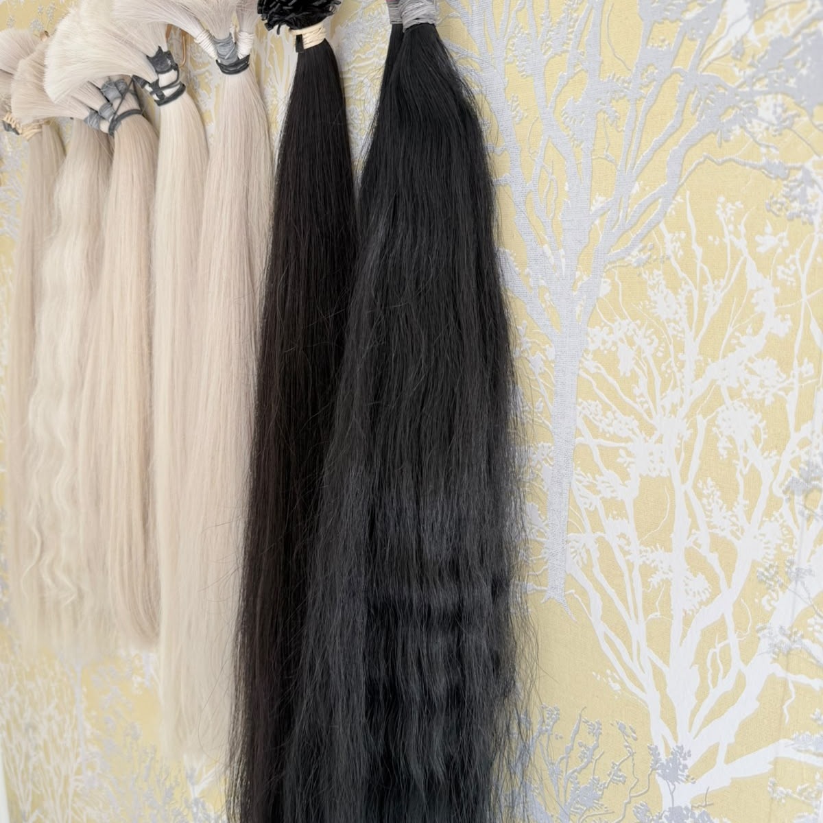 Selection of premium Russian hair extension colours hanging in the studio